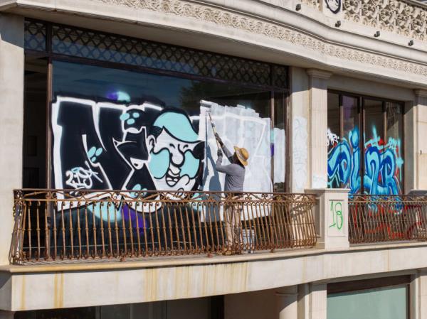 A worker pastes over graffiti on the Mulholland Drive mansion.