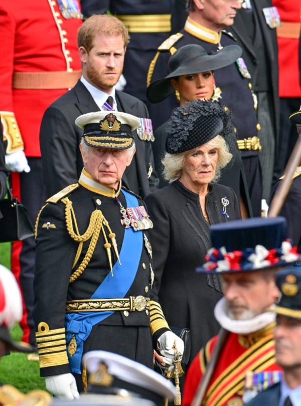 Members of the British royal family, including Prince Harry, King Charles III, and Duchess Meghan, standing near Wellington Arch during Queen Elizabeth II's State Funeral in London, England.