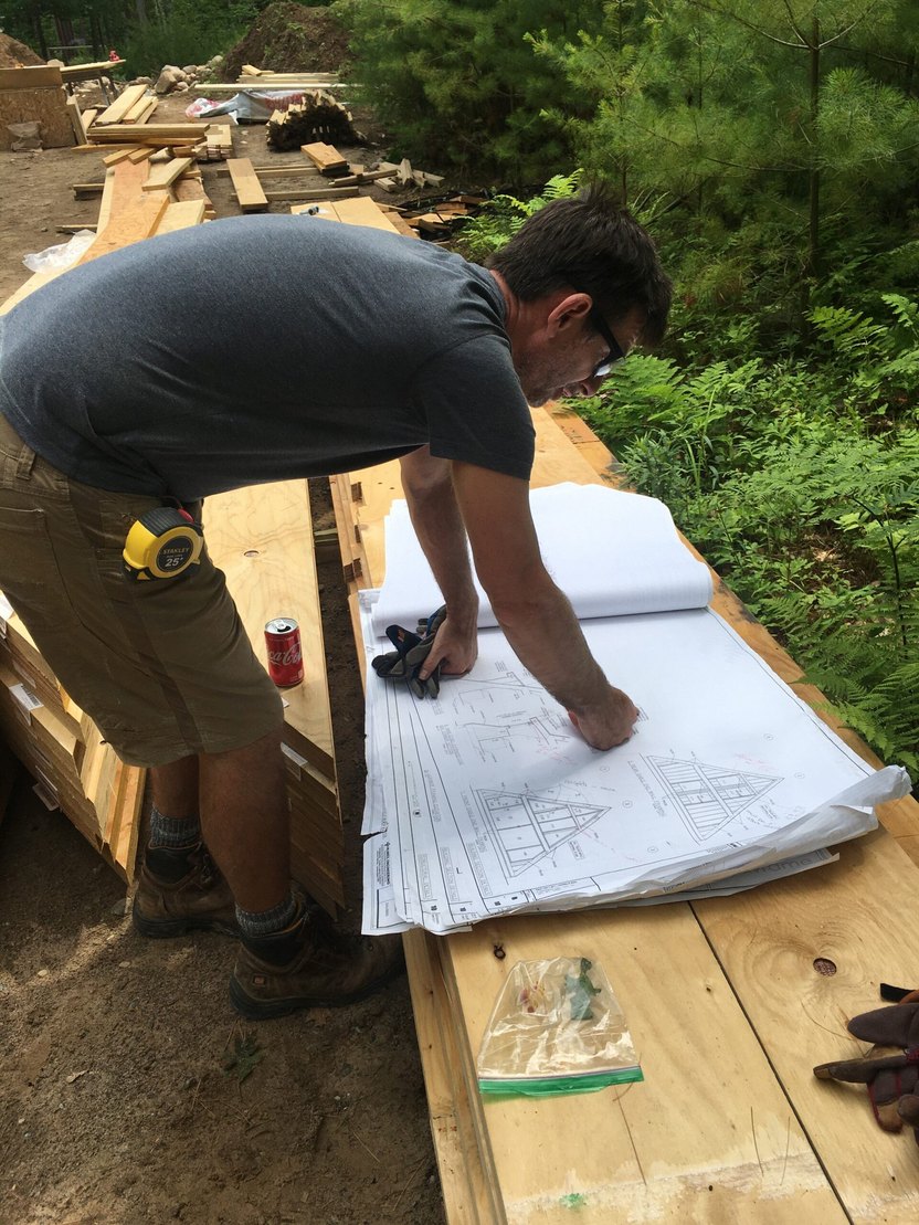 Robert Daniels looking at architectural plans for his A-frame cabin.